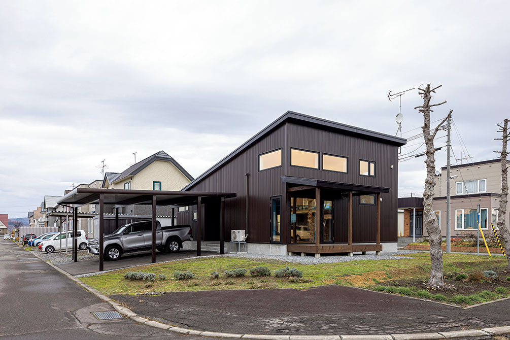 角地に立地し、片流れ屋根が特徴のシンプルでシックな外観。カーポートや屋根付きのウッドデッキも備えた