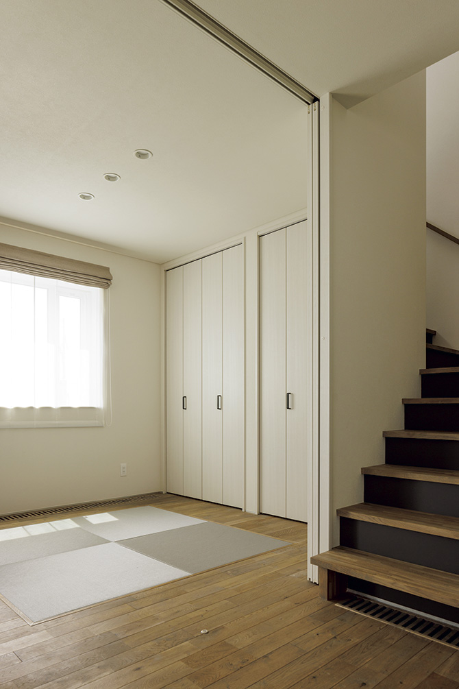 リビング続きの部屋は一部に琉球畳を敷いて和室に。階段の蹴上げ部分をグレーにしたのがこだわり